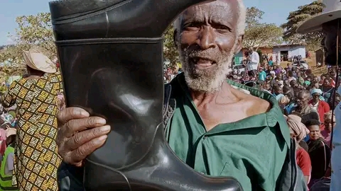 A Meru resident holds gumboots given to him by the Governor at Mbaaria Market during Okolea Kaana Ka Miiru 